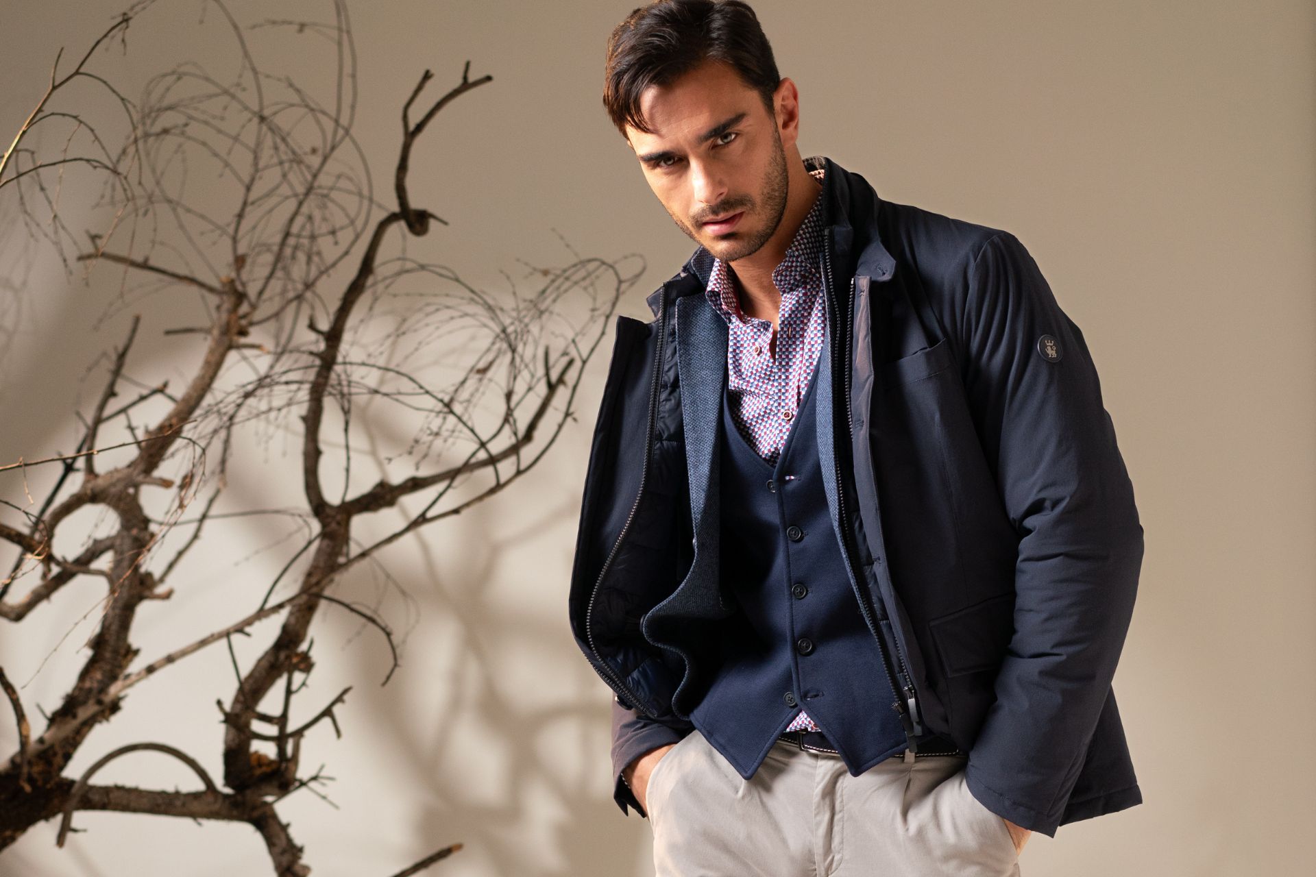 Ragazzo che cammina con giacca sfoderata blu, gilet e camicia